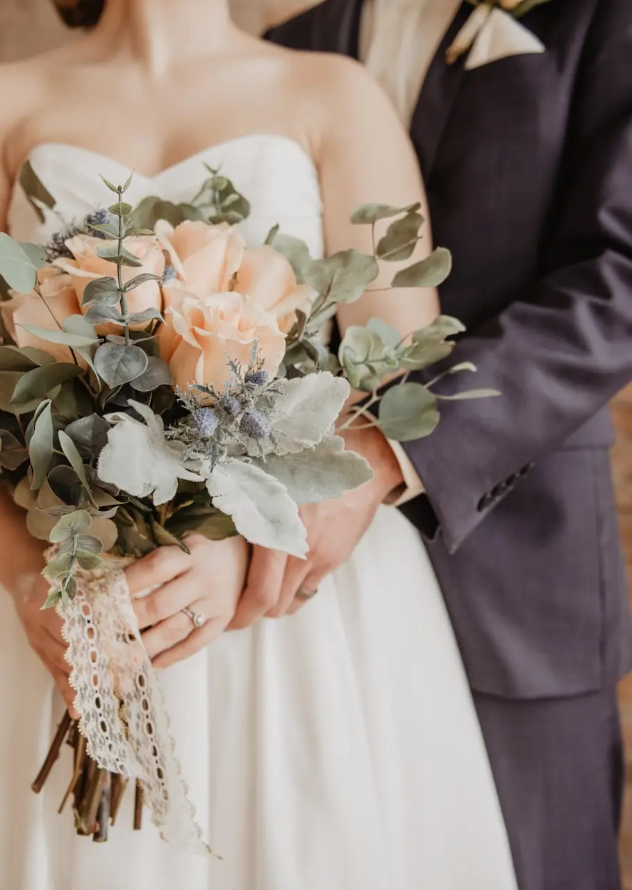 una mujer sosteniendo un ramo de flores con pétalos de color crema