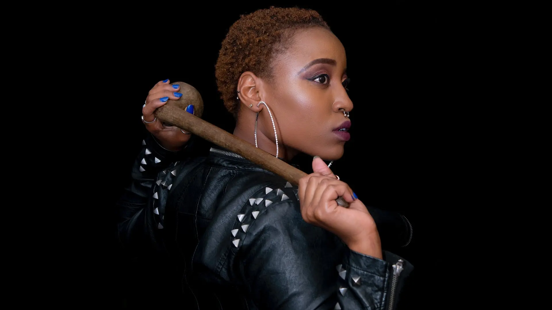 una mujer posando con herramienta de madera en la mano